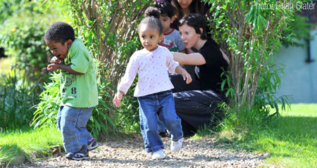 Watched by Sophie Adler Children hunt for the 'bear' in the school's garden.